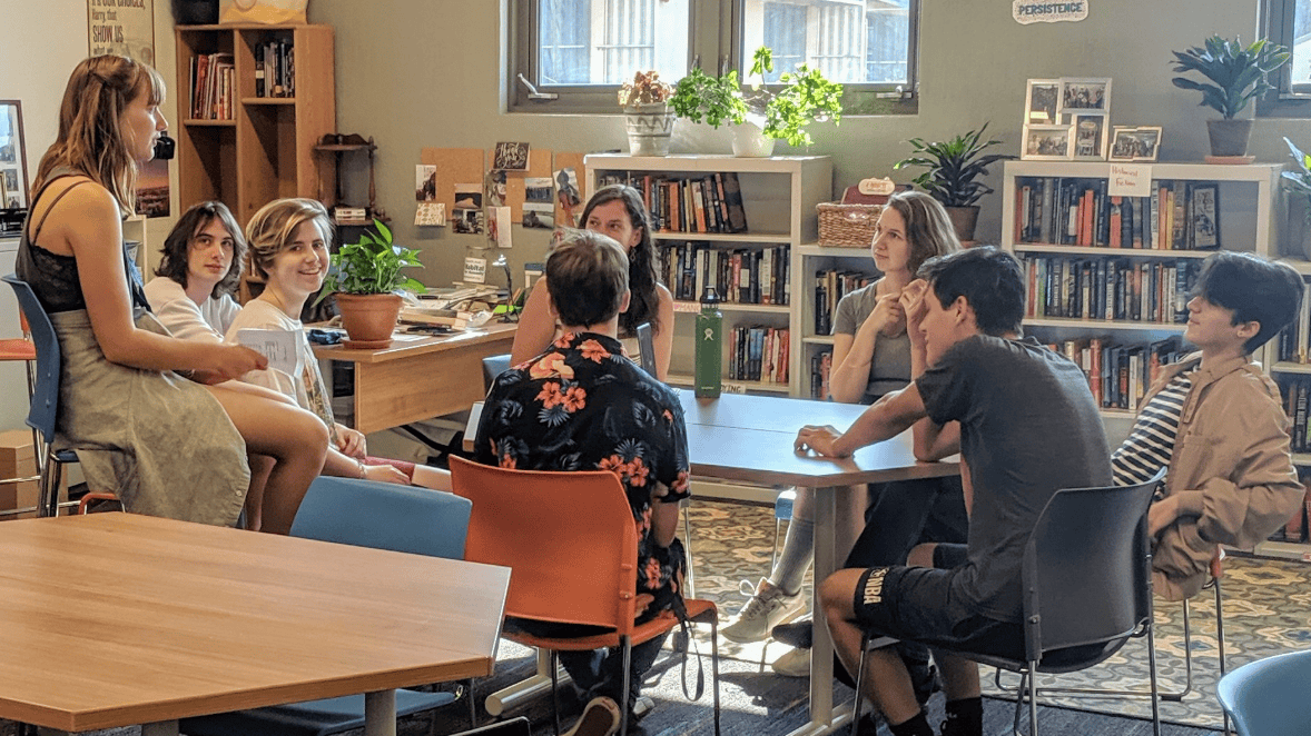 Students having a classroom discussion sitting in a semi-circle.