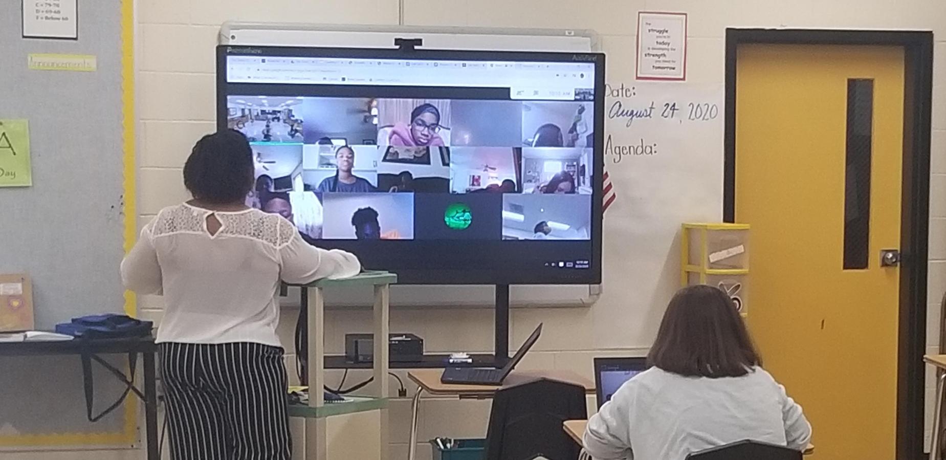 Ms. Sanders teaching virtually with face to face student