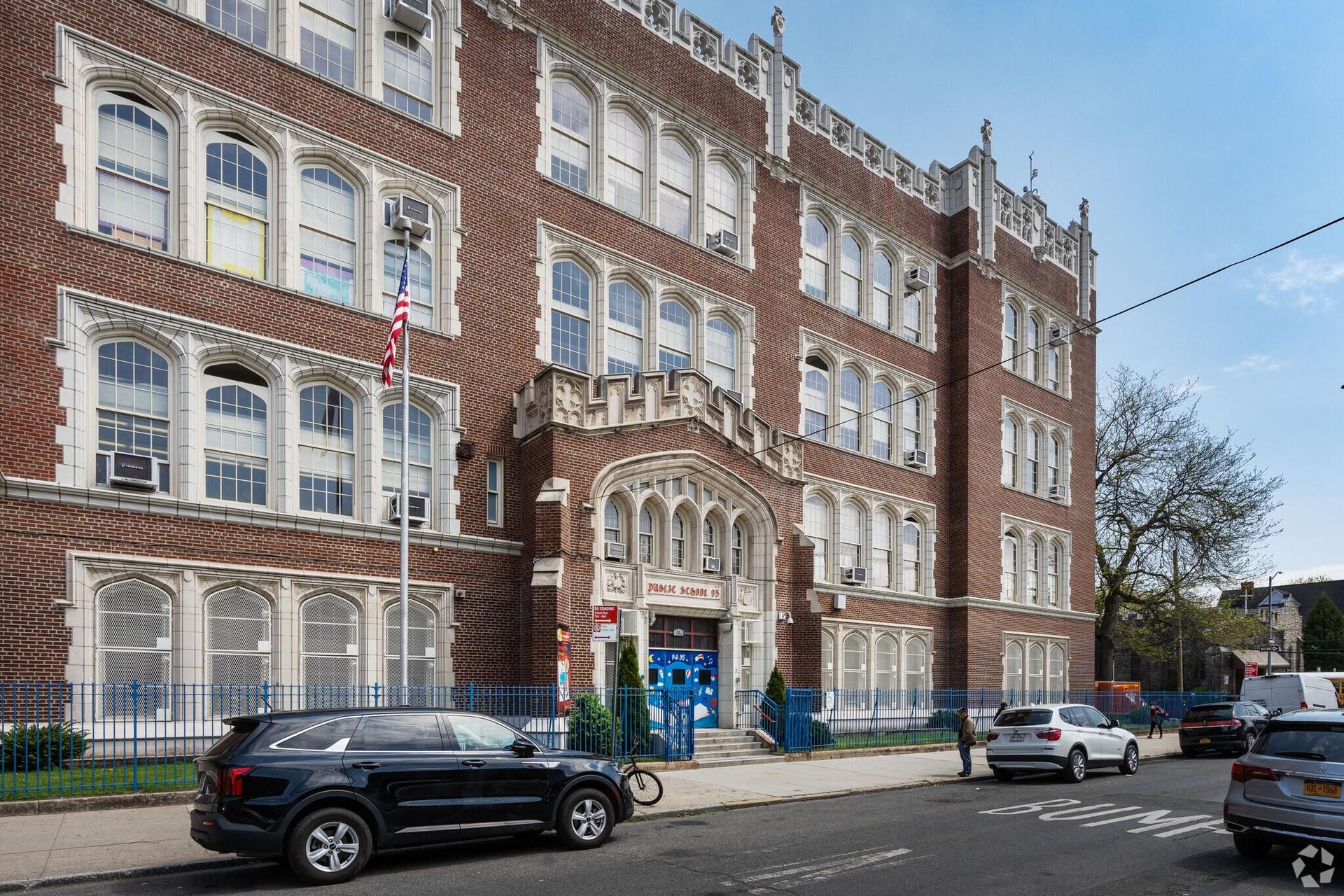 Historic brick school building with large windows and central entrance.