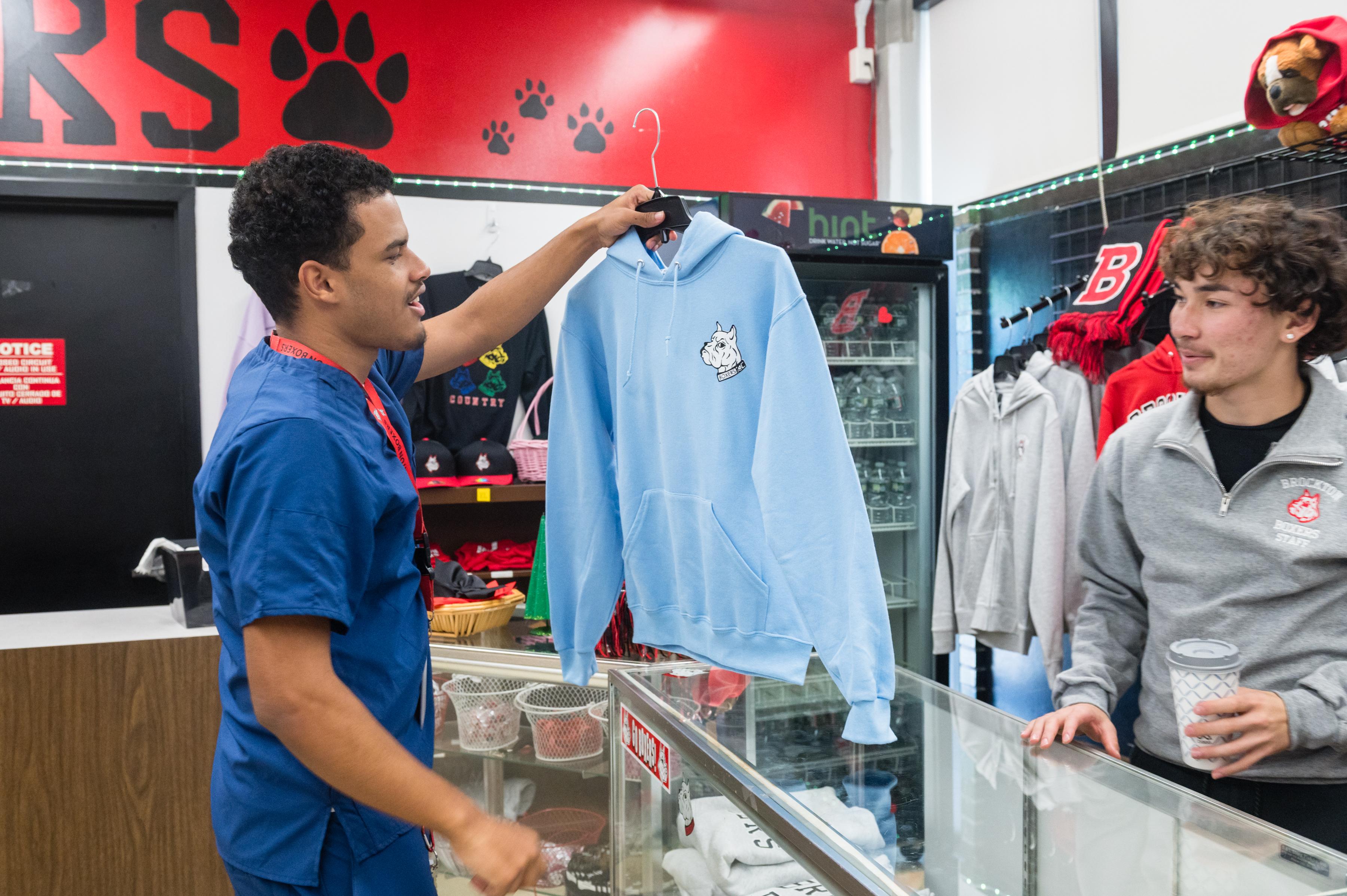 Students interact over a piece of BHS merchandise in the DECA store