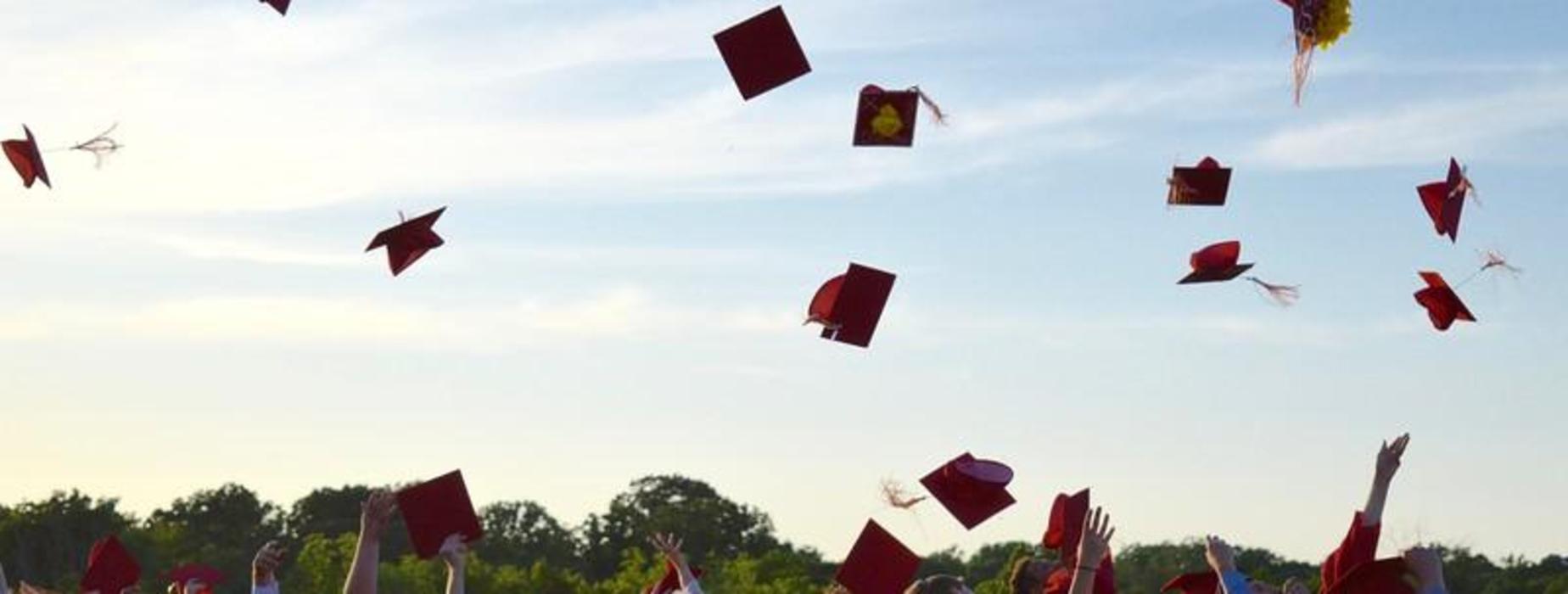 Graduation Caps flying in the air