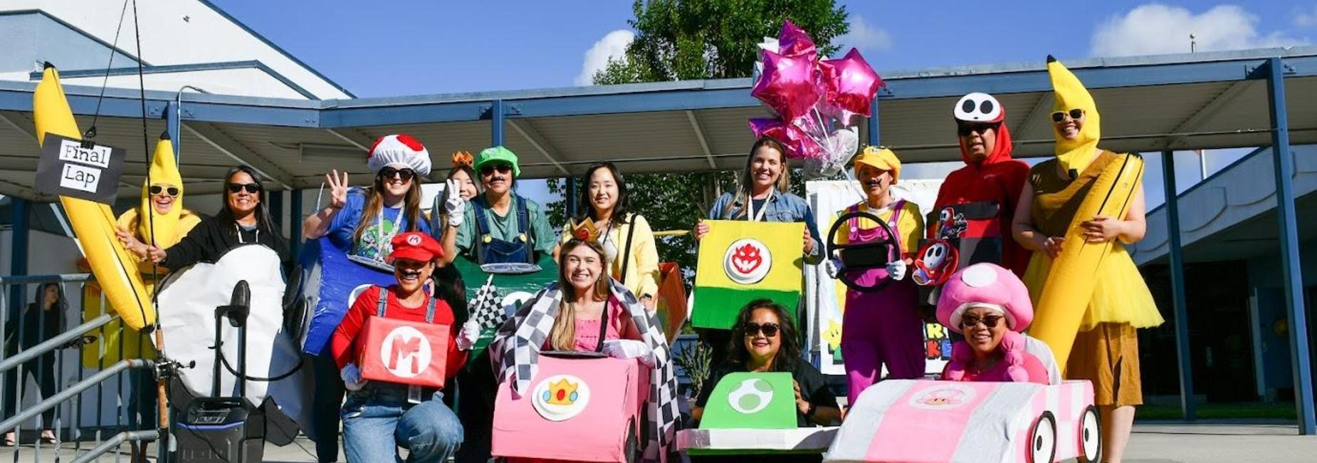 Group of people in costumes inspired by Mario Kart, posing with colorful decorations.