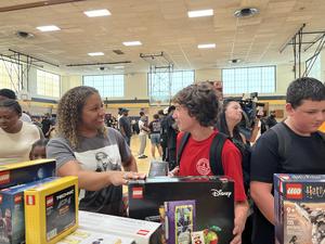A BPS staff member hands out LEGOs to a student