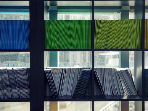 colorful books on a shelf in front a window