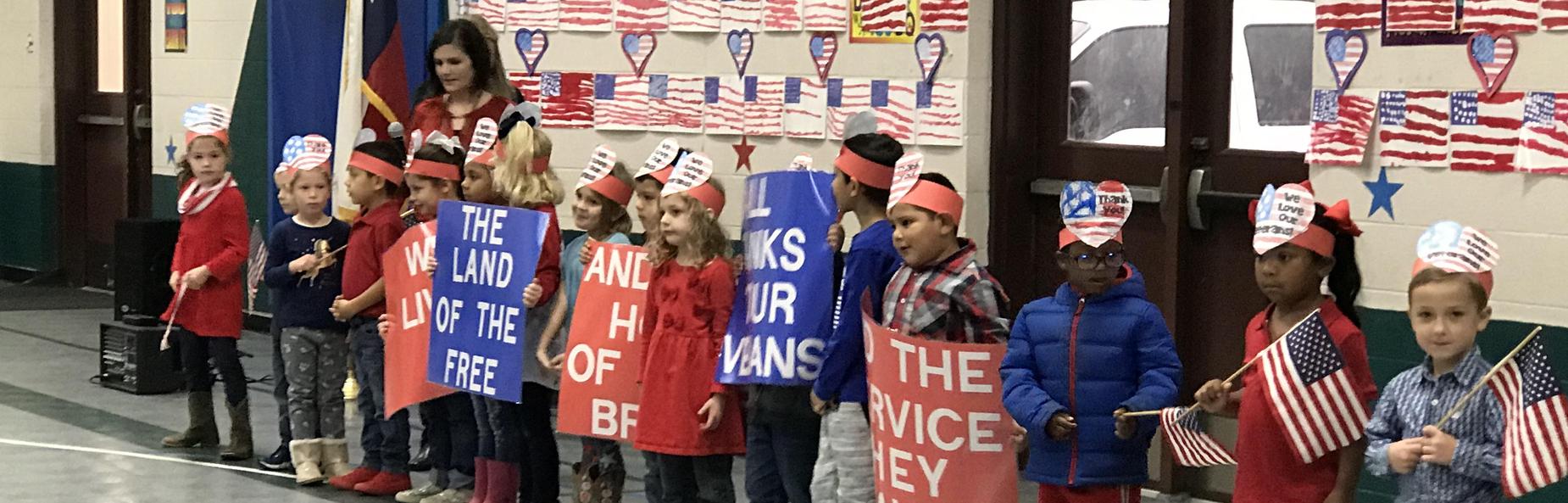 children holding american flags and patriotic signs