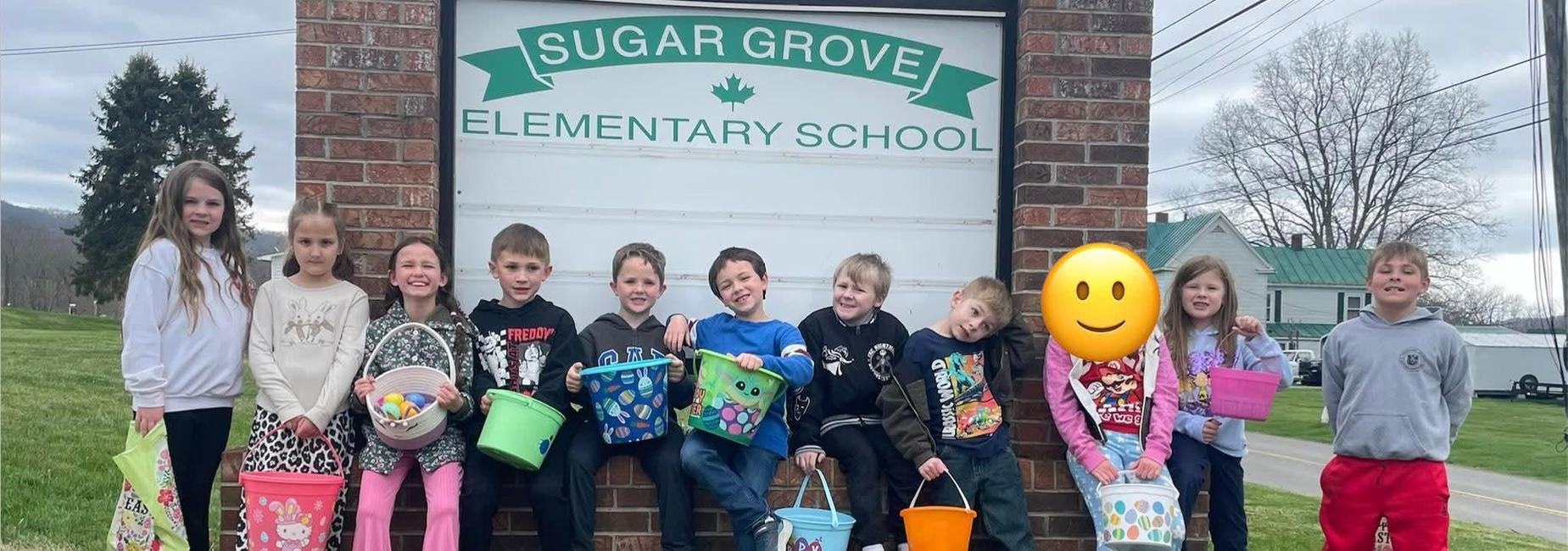2nd graders pose in front of the "Sugar Grove Elementary"  school sign after their Easter Egg Hunt