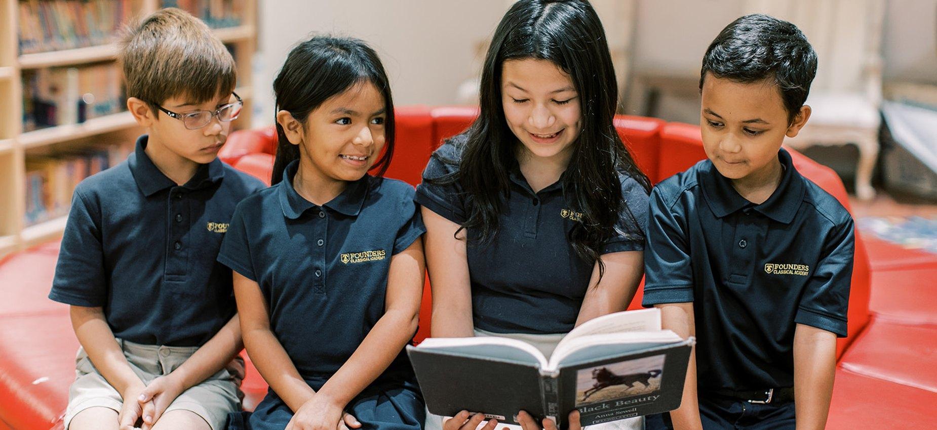 Founders Classical Academy of Corinth students sharing a book in the school library