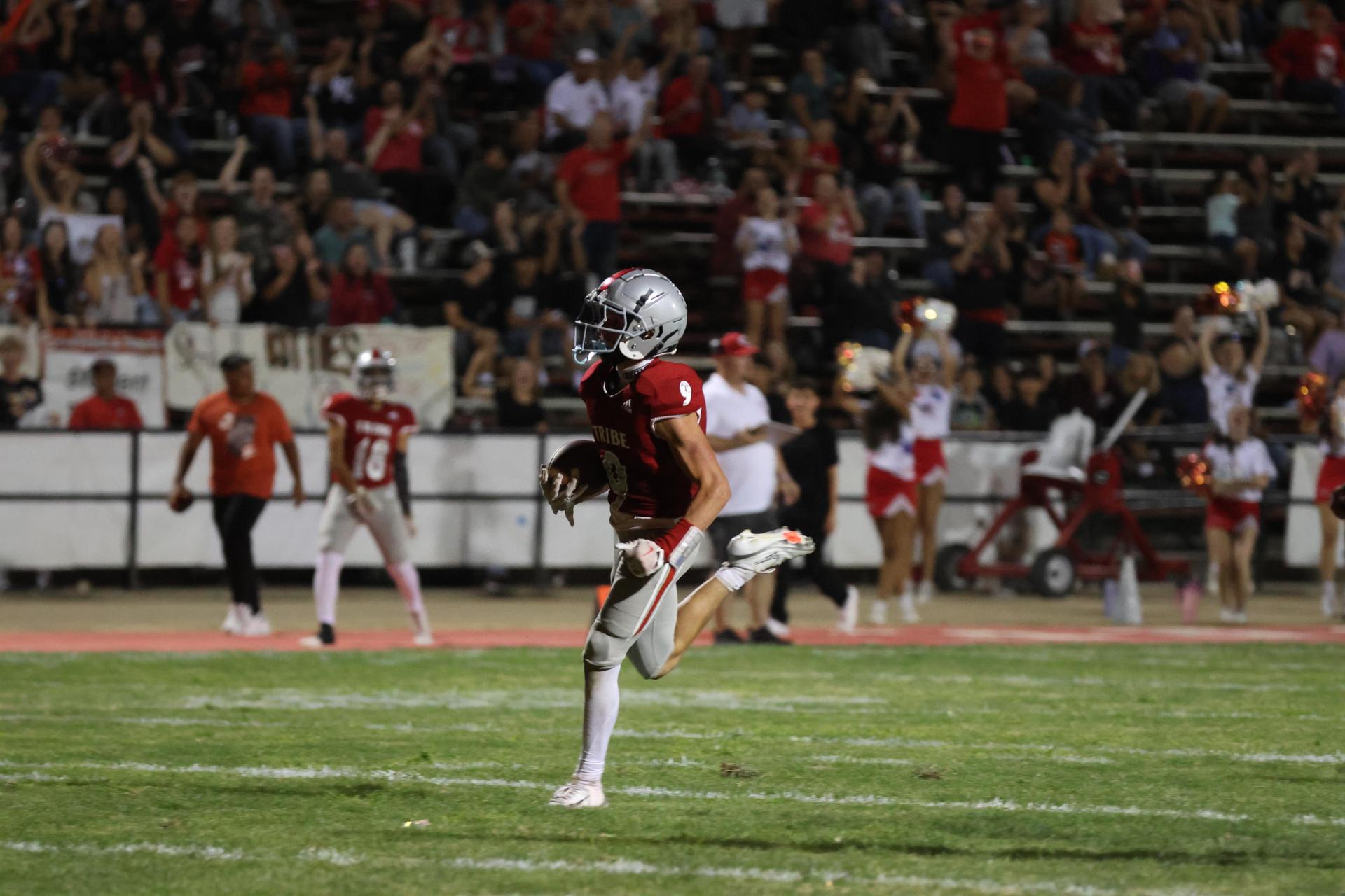 Varsity football players in action against Parlier 52