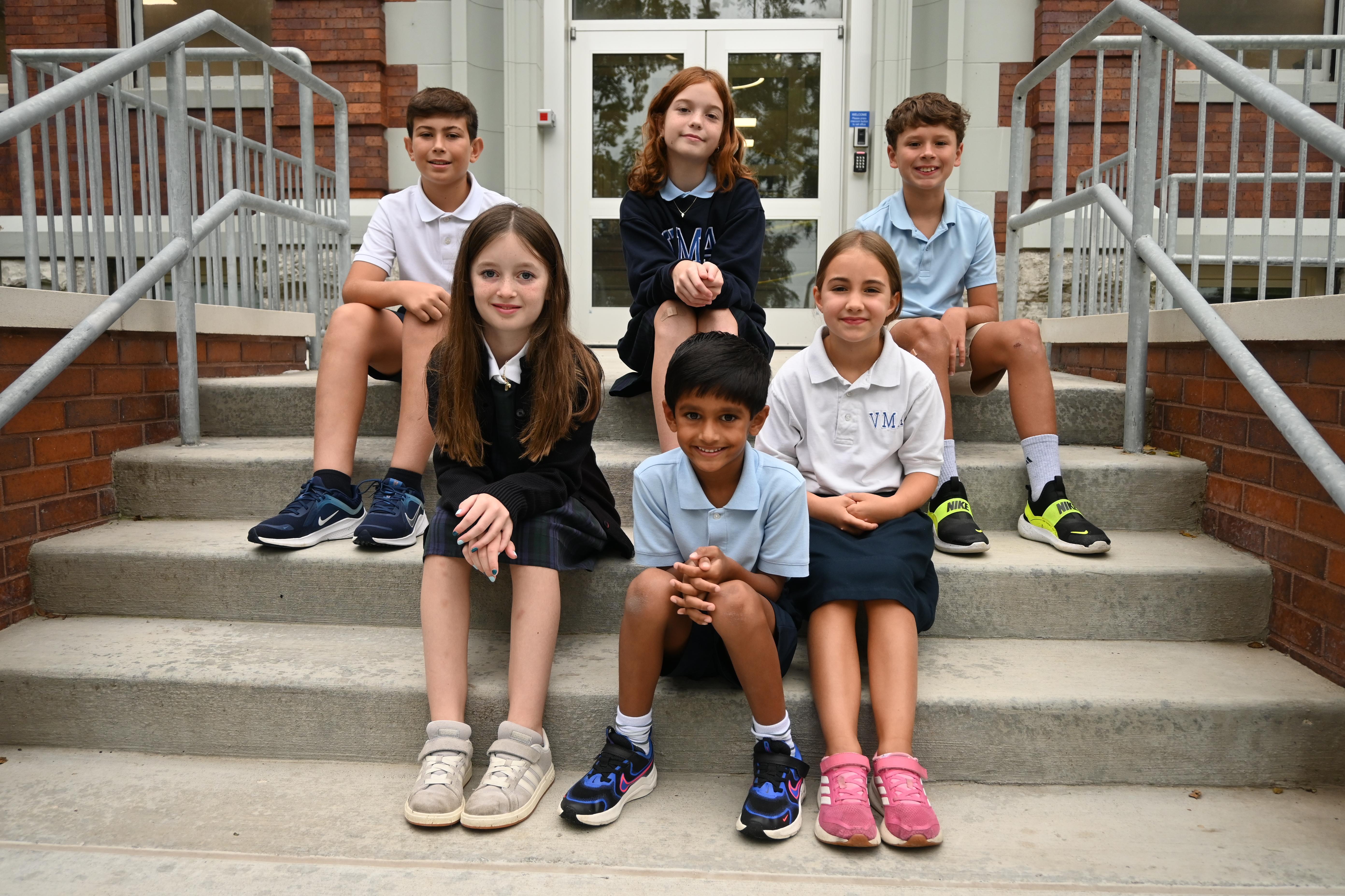 Elementary students sitting on school steps