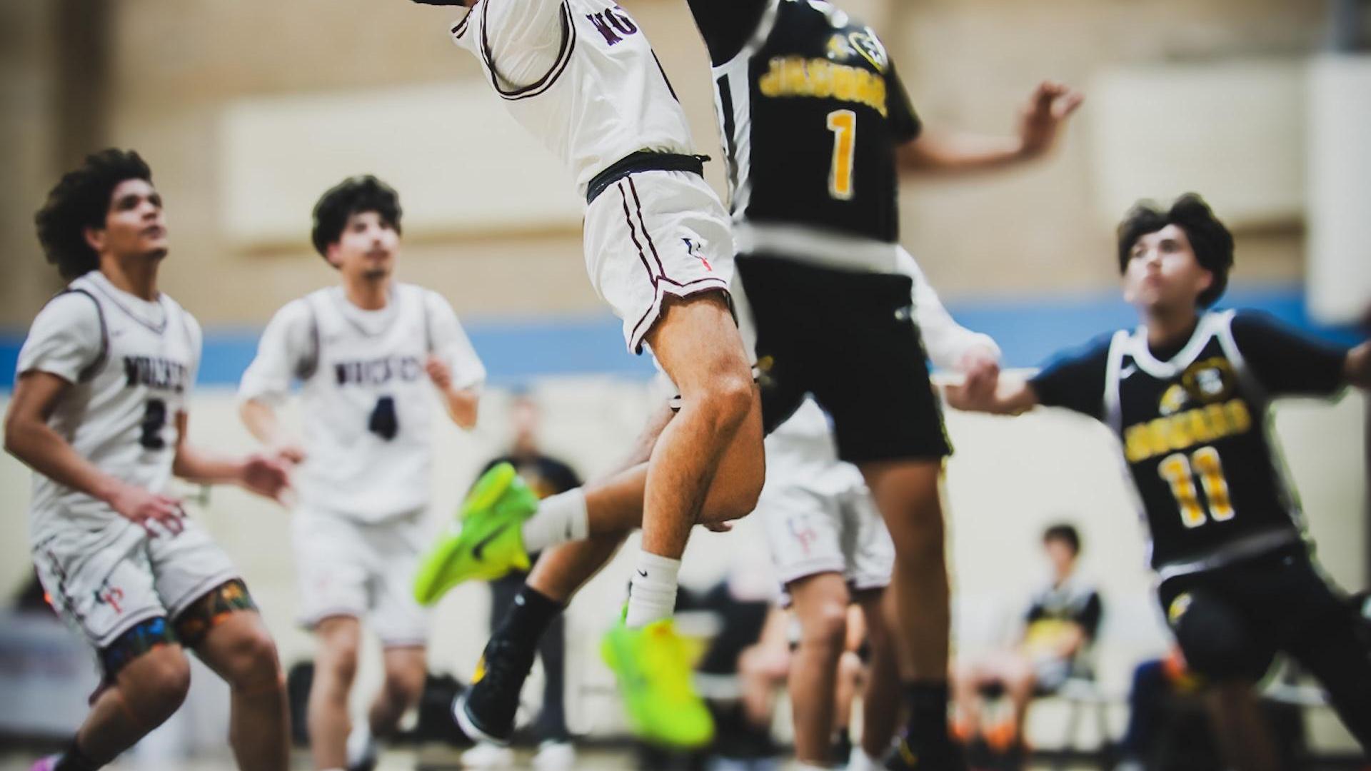 Players jumping in action during a basketball game.
