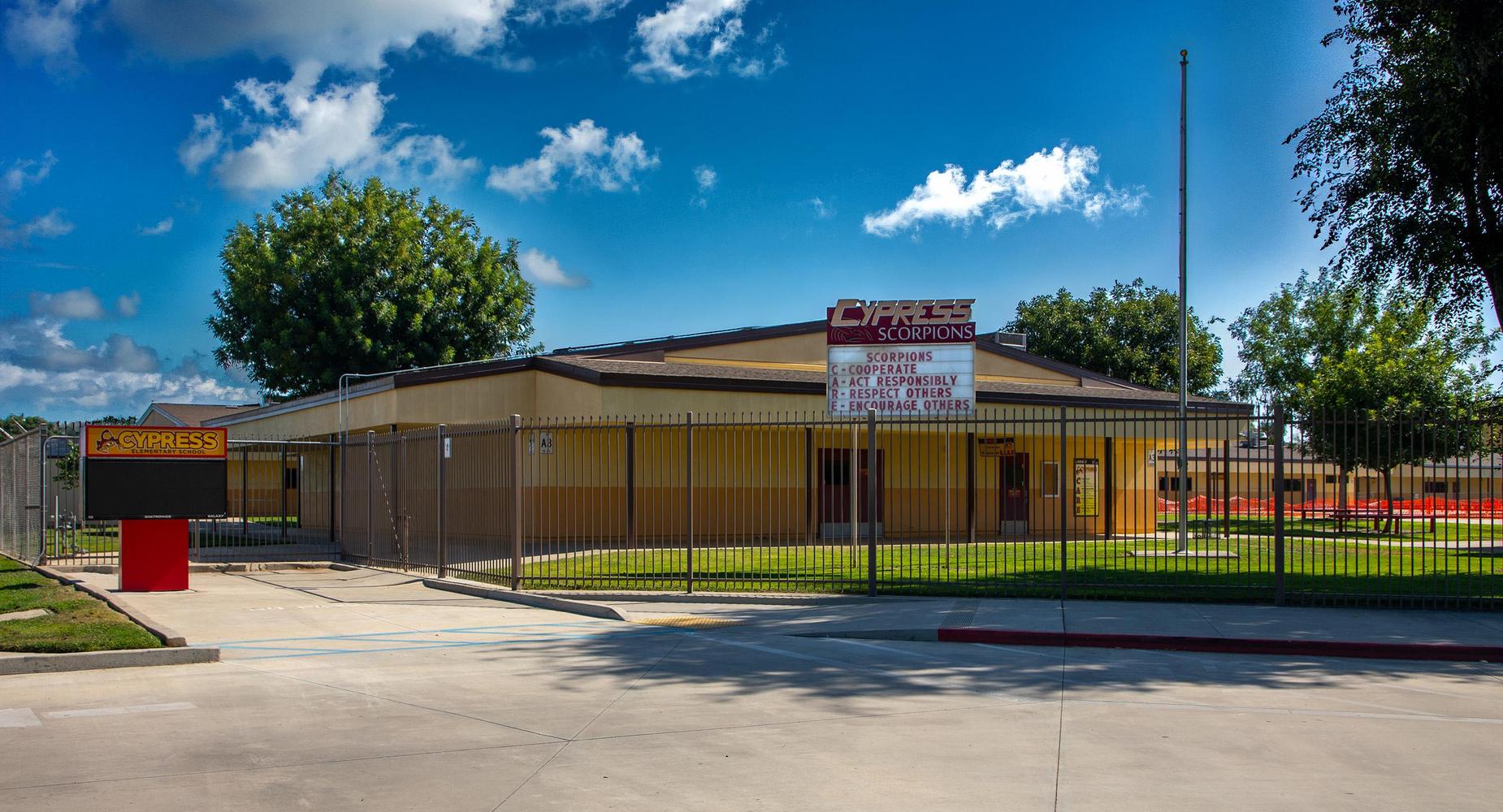 Cypress Elementary school building with a sign for Cypress Scorpions and a fenced yard.