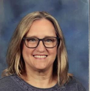 Rachel Harris wearing glasses and smiling in a school picture setting