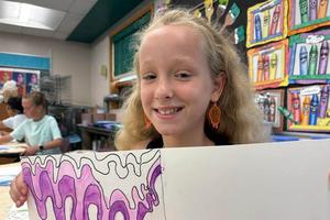 Rosalee Palko wears earrings that mimic the design of her artwork