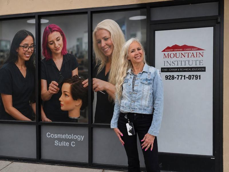 Cosmetology Instructor standing in front of the building with mural