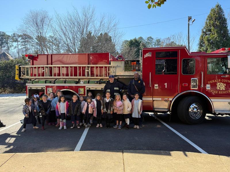 The kindergarten class poses in front of the fire truck