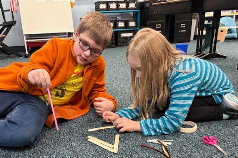 Sunrise Elementary first-graders Sullivan Frame and Juliet Shaffer work together to build their bow and arrow