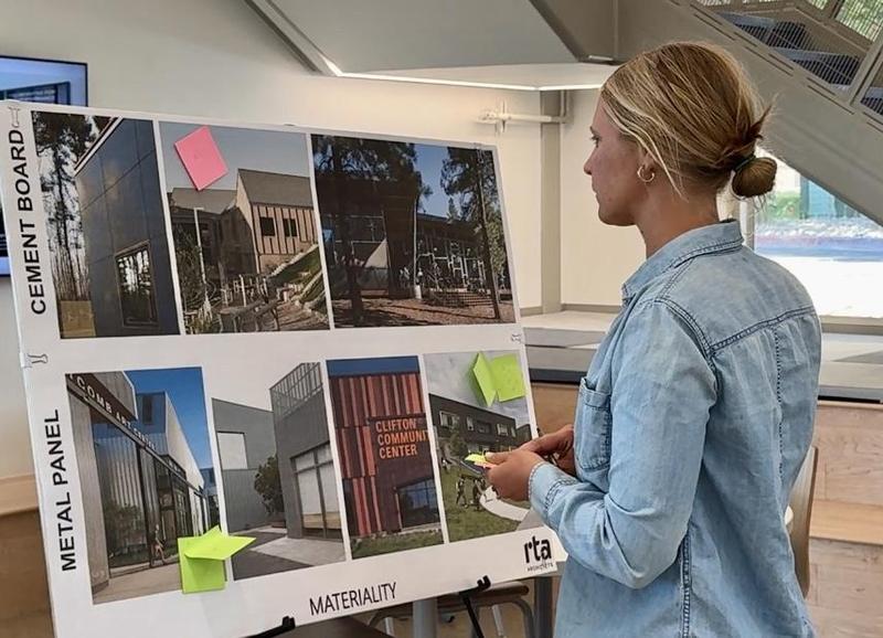 Woman looks at board with school design materials