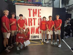 6 boys and 2 girls pose with "Art by Banksy" sign