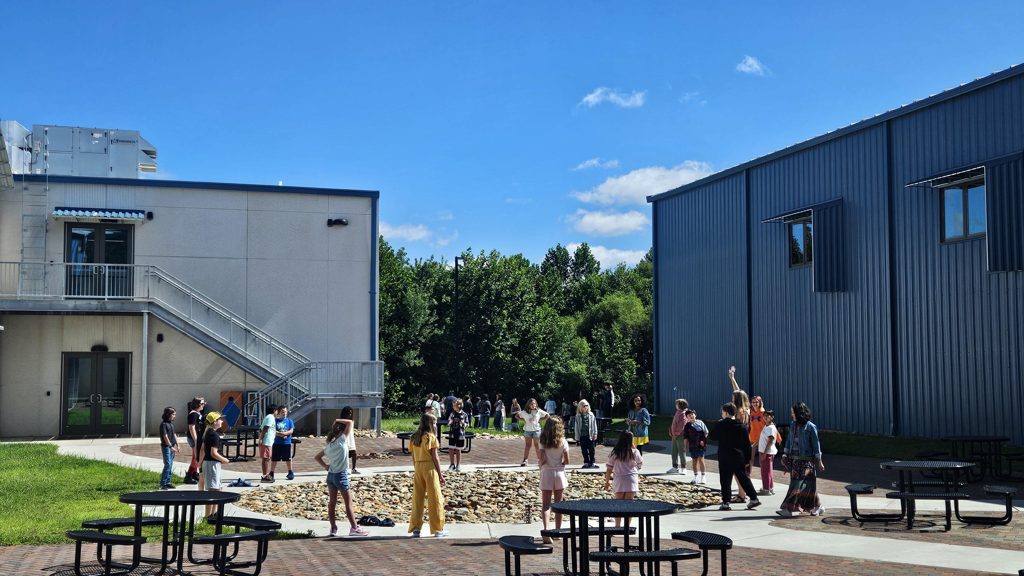 Students meet in a circle in the school courtyard