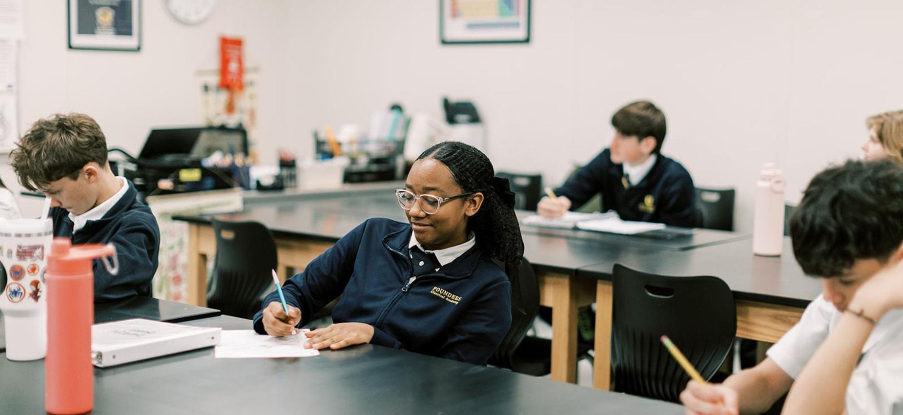 Middle school student smiles while working in a science classroom