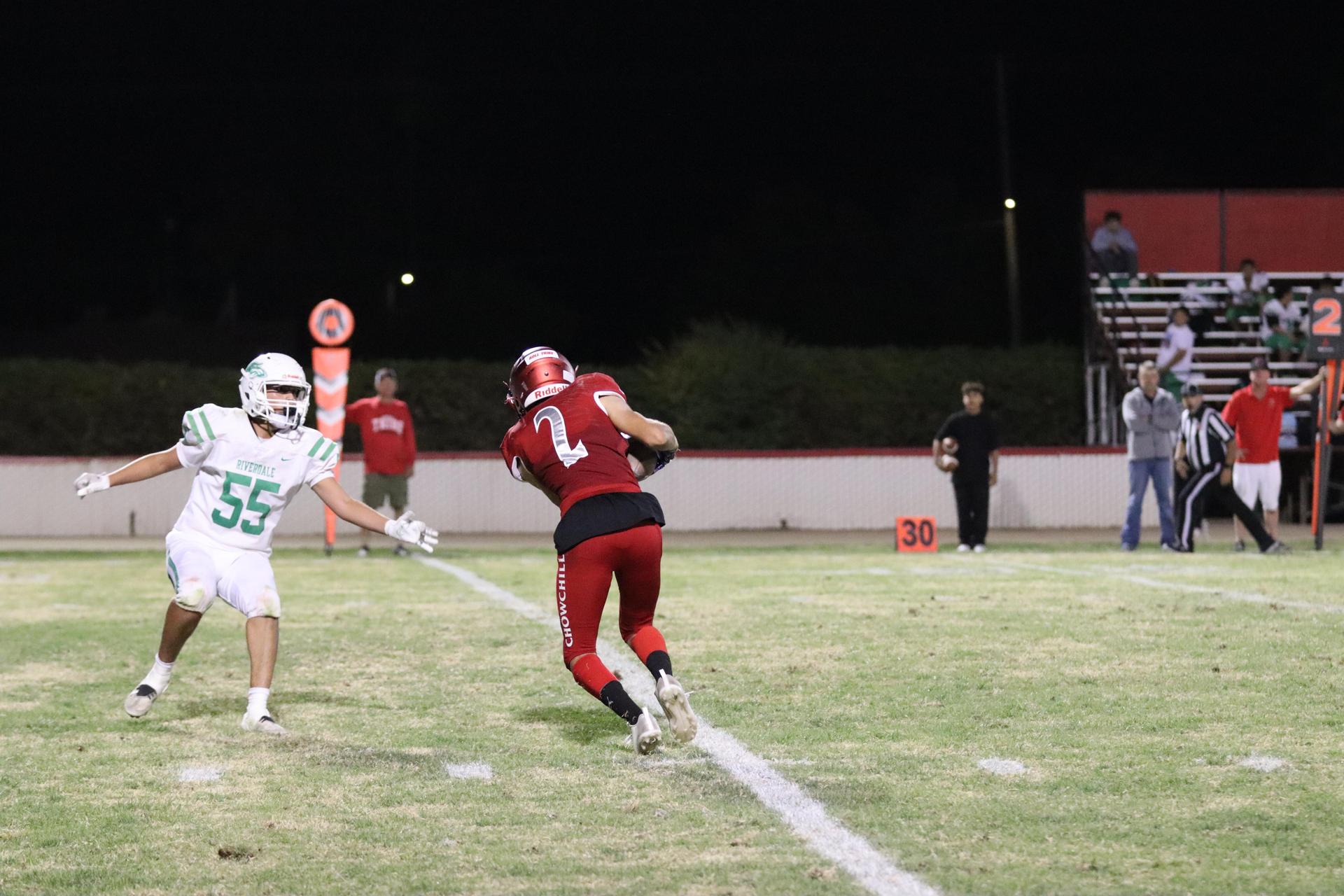 varsity football players in action against Riverdale