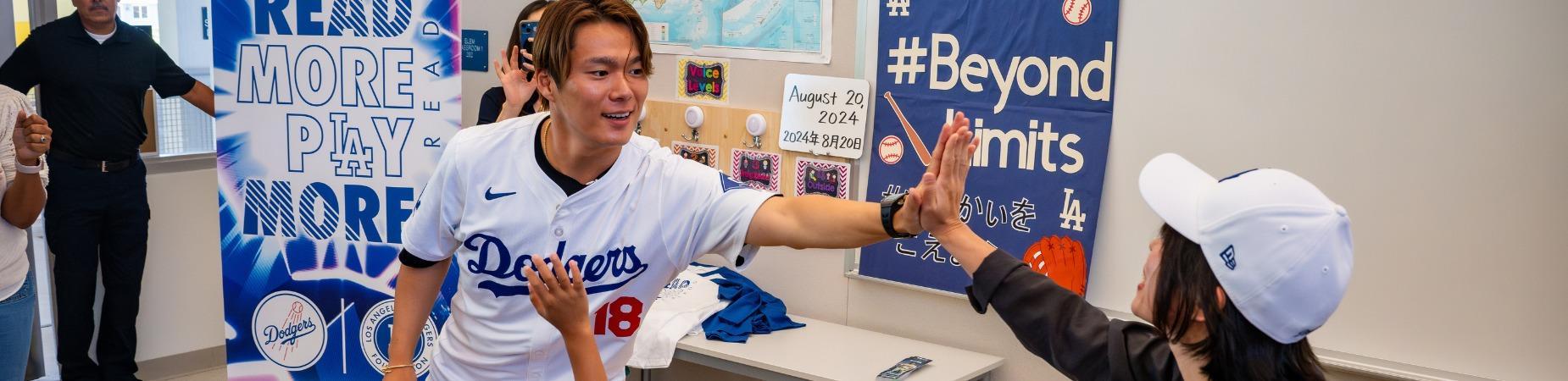 yoshinobu yamamoto of the dodgers high fives someone