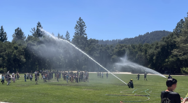 Photo of the firefighter hose spraying down the Charter students