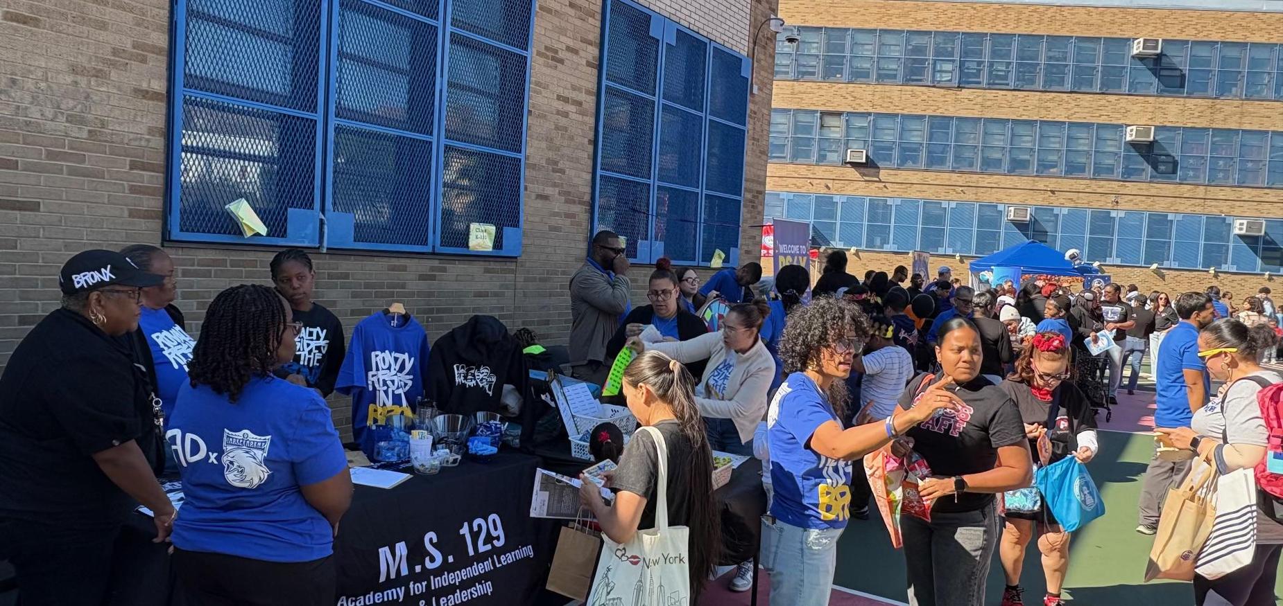 crowd of people standing in a school yard for a community event