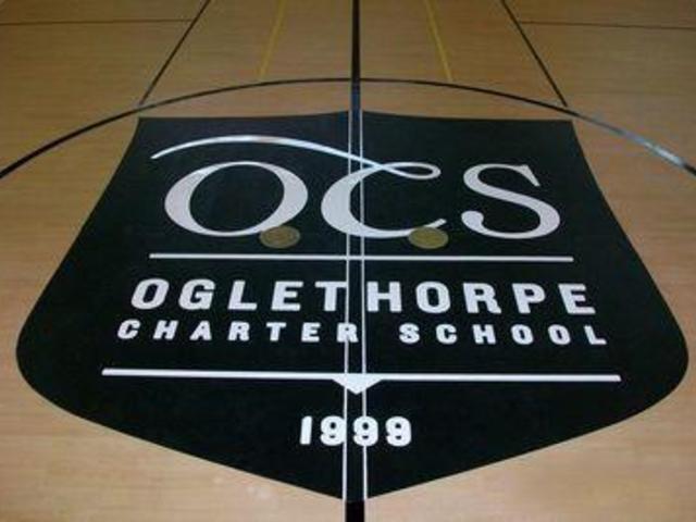 Logo of Oglethorpe Charter School on gym floor.