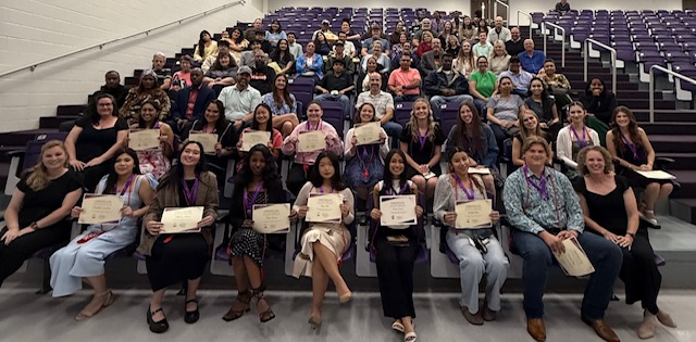 Smiling students holding acheivement certificates