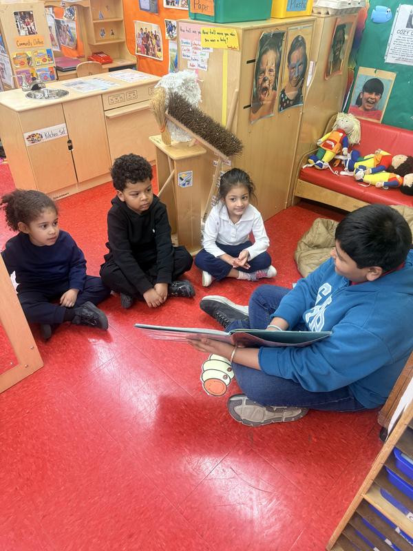 Student reading and showing pictures of the illustrations