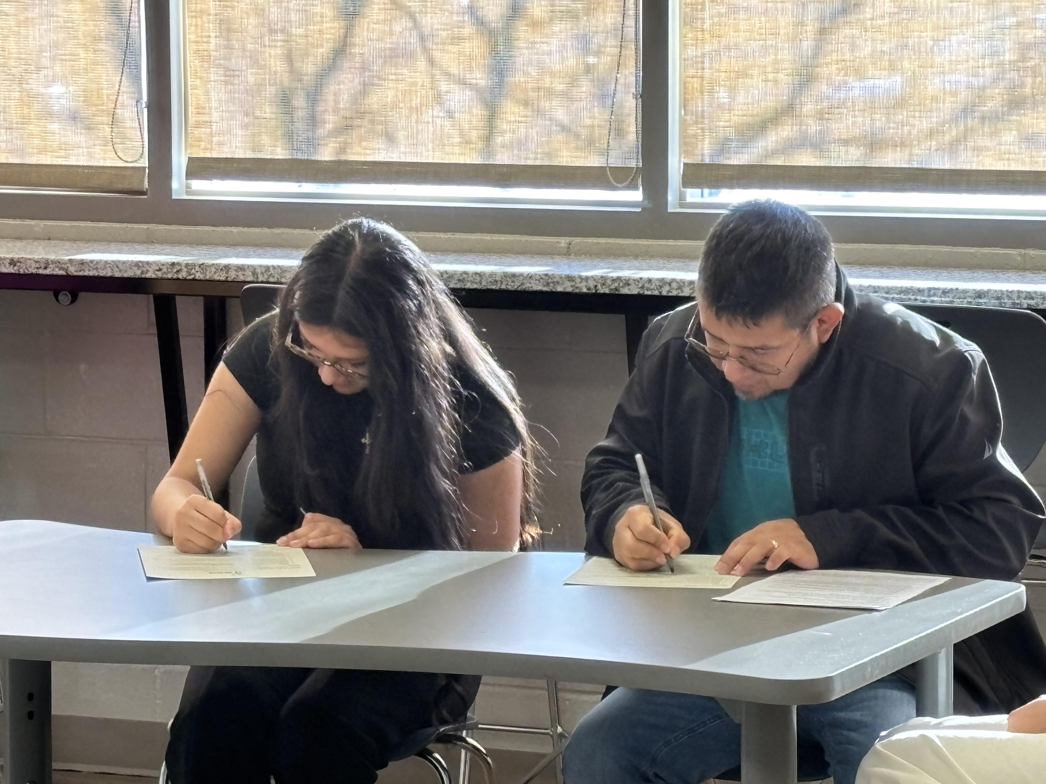 Jennifer is signing her scholarship agreement