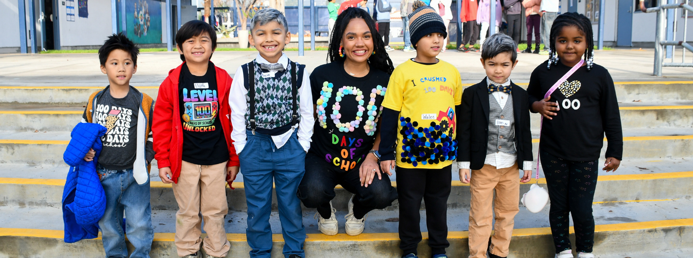 A joyful group of children and an adult, all dressed in creative outfits celebrating a special event.