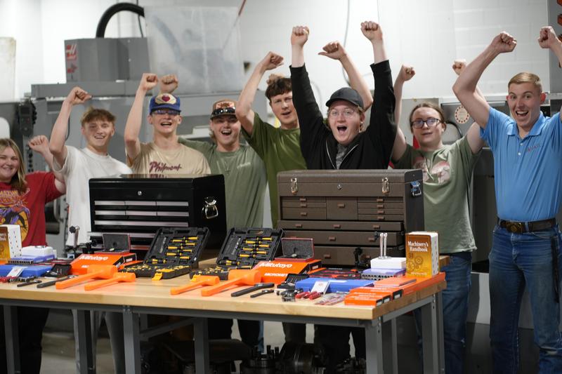 students cheering behind a set of tools on a table