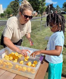 Child and student at duck pond game.