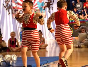 Two students dressed as strong men flexing arm muscles