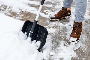 Snow shovel clearing snow from a path.