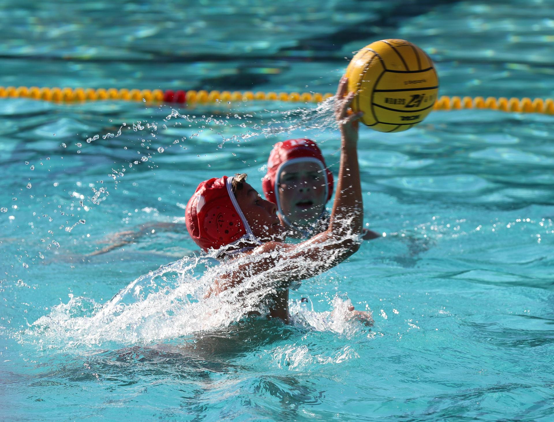 boys water polo players in action against hoover