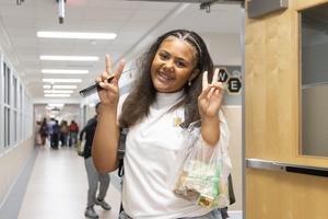 A middle school girl shows a peace sign