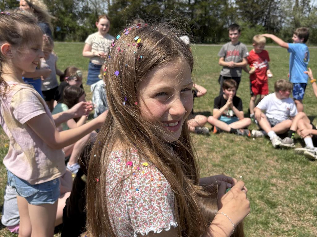 A student outside with confetti in her hair.