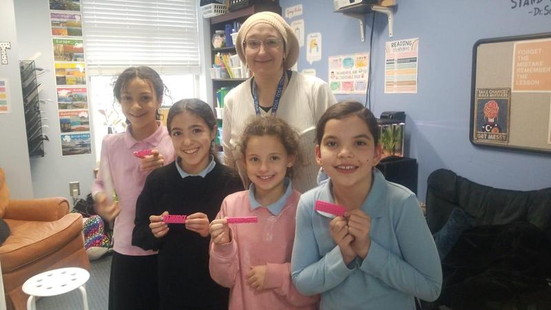 Fourth grade girls show off their personalized name key chains that they designed themselves.