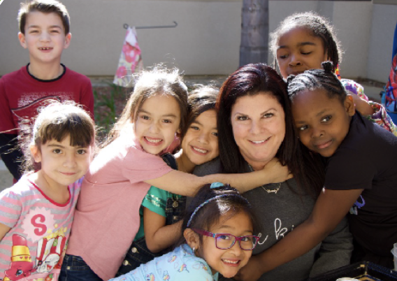 Teacher with students hugging teacher