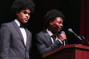 Close up of 2 seniors in tuxedos presenting at the Oscar Night