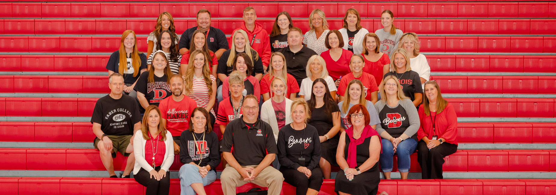 Oklahoma faculty and staff wearing school colors on red bleachers.
