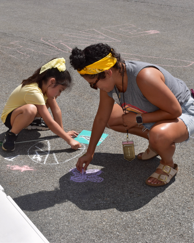 Student and teacher draw together with chalk