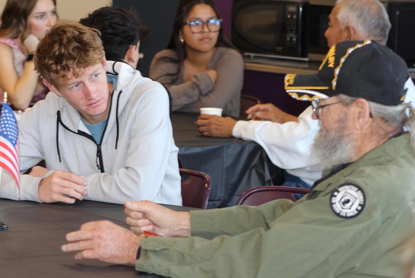 A student visits with a veteran