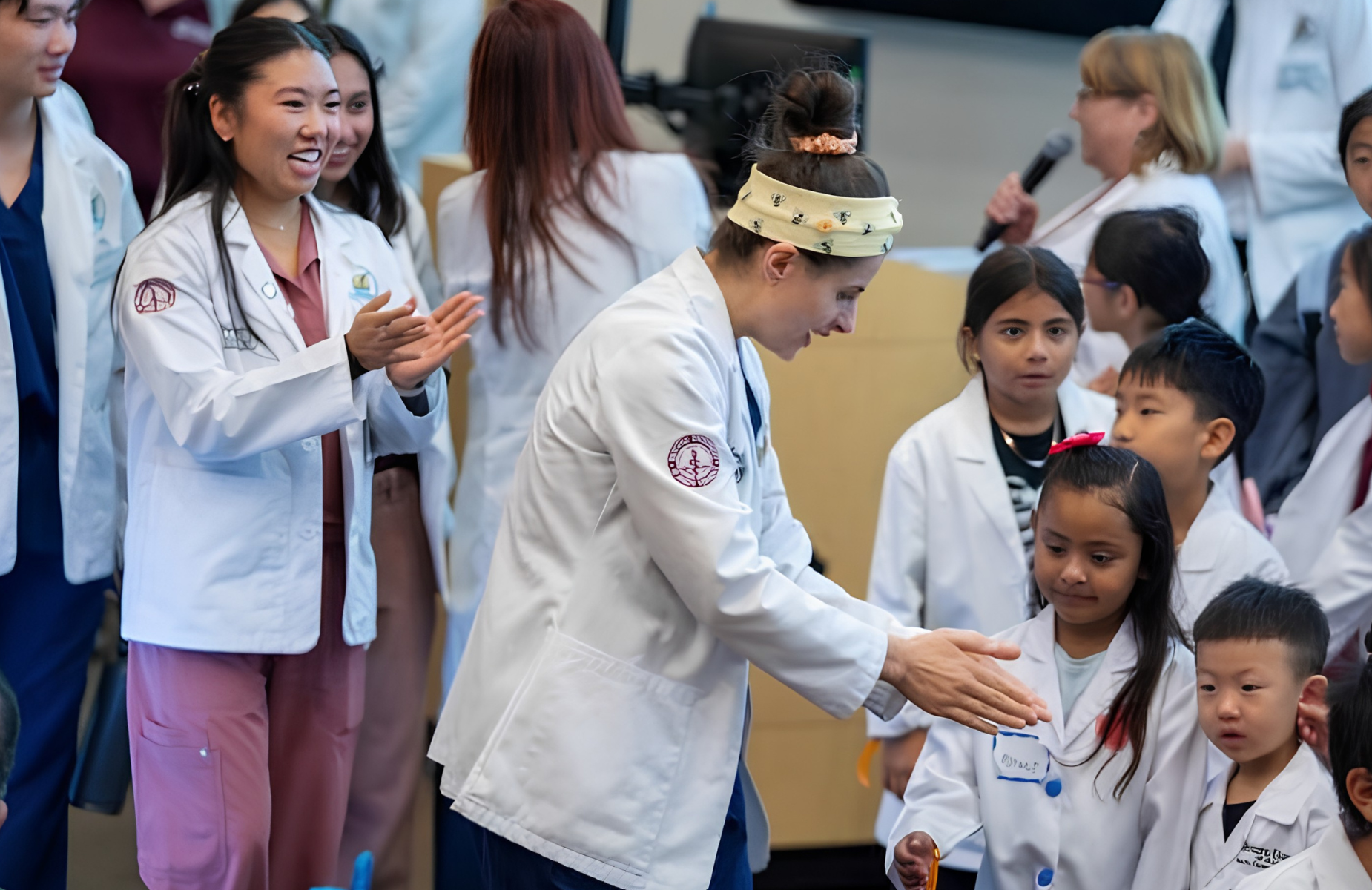 Health Career Ladder (HCL) Banner for the homepage: a medical student from Western University with PUSD students under the age of 10 at a Saturday Academy Class.