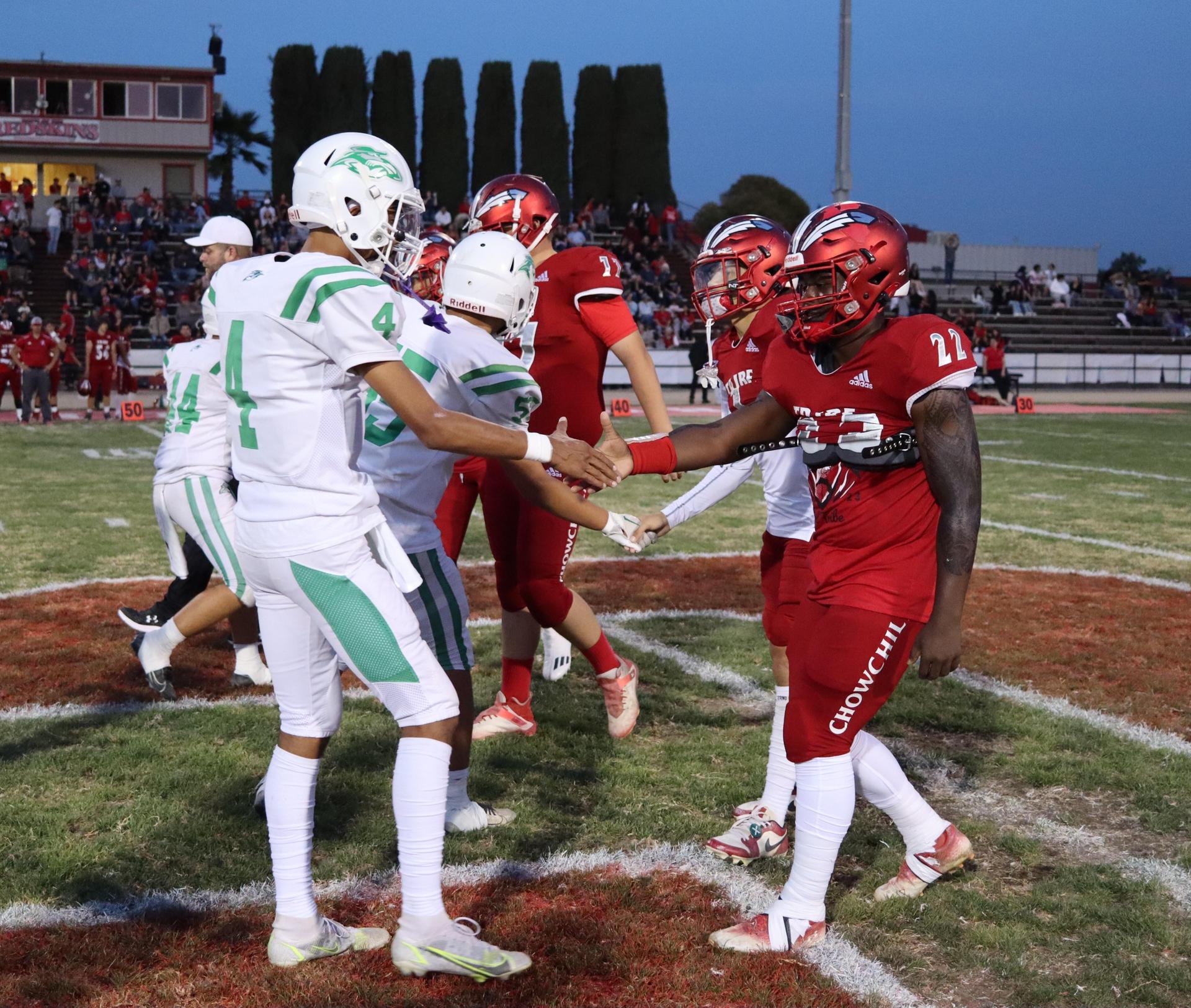 varsity football players in action against Riverdale