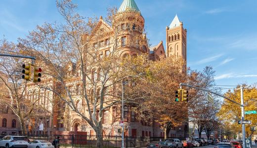 Grand architectural structure with a green turret and surrounding trees.