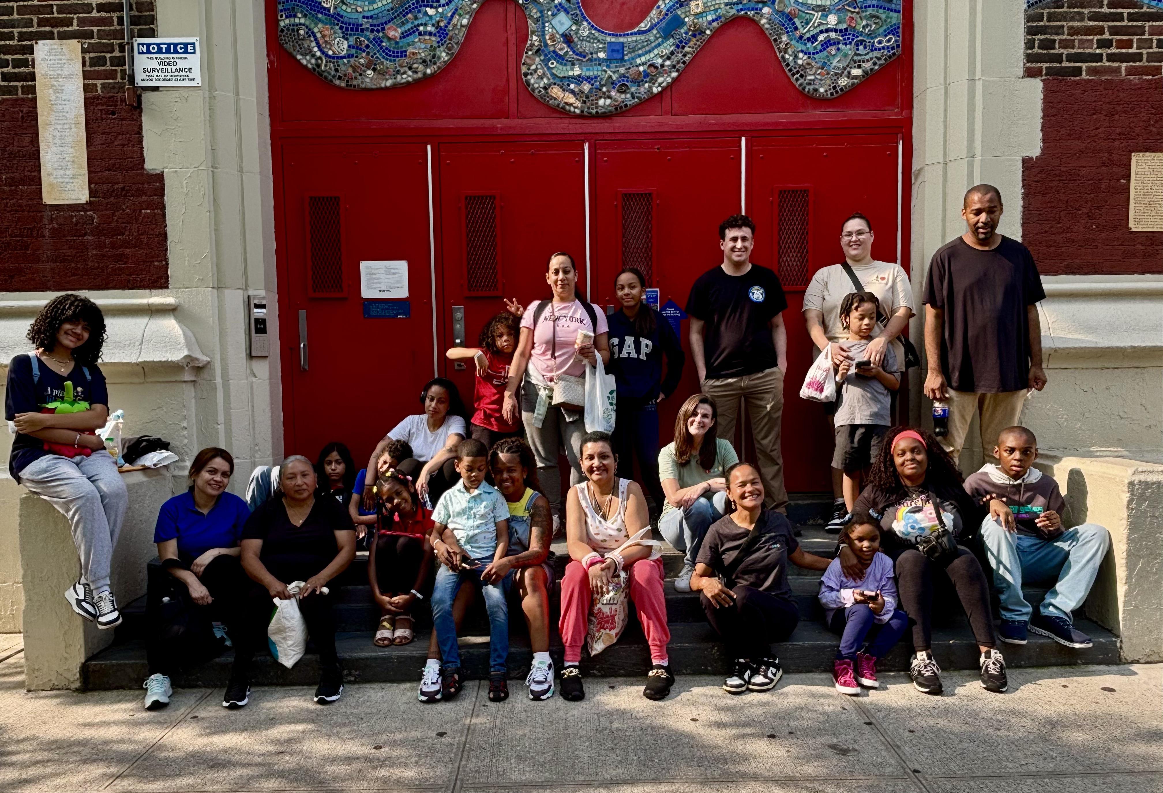 Families and staff sitting in front of red stairs